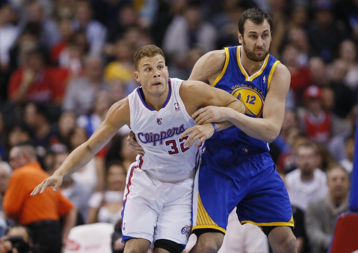 Clippers power forward Blake Griffin, left, battles for position with Golden State Warriors center Andrew Bogut during the first half of Wednesday's game at Staples Center.