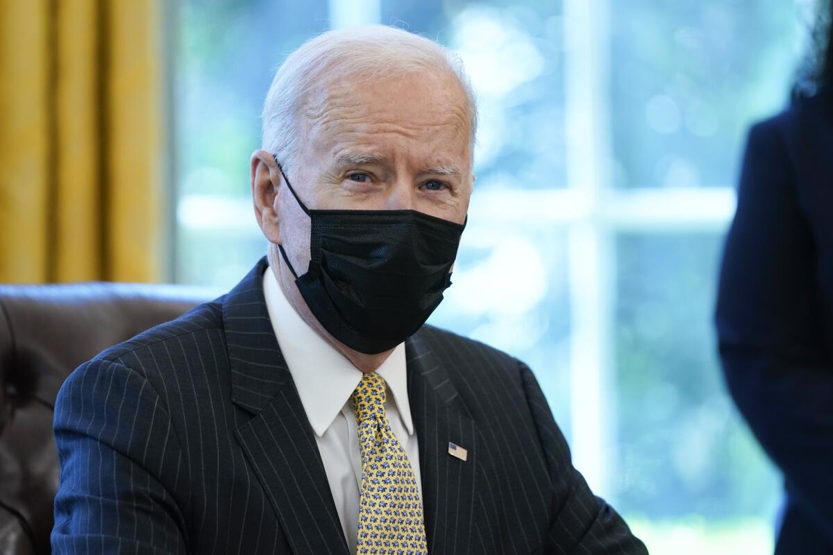 Closeup of President Biden seated and wearing a mask.