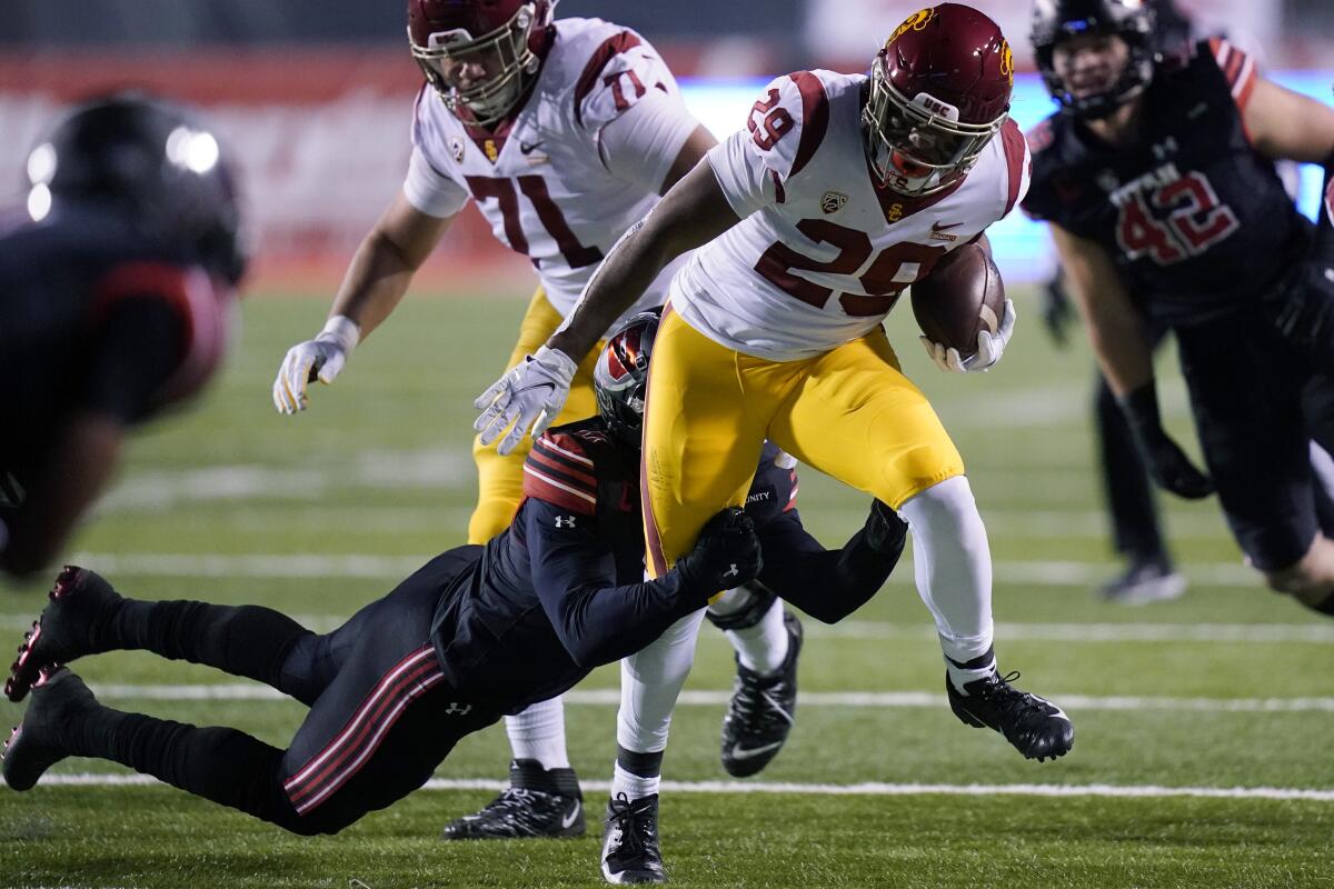 USC running back Vavae Malepeai drags a Utah player along on a carry.