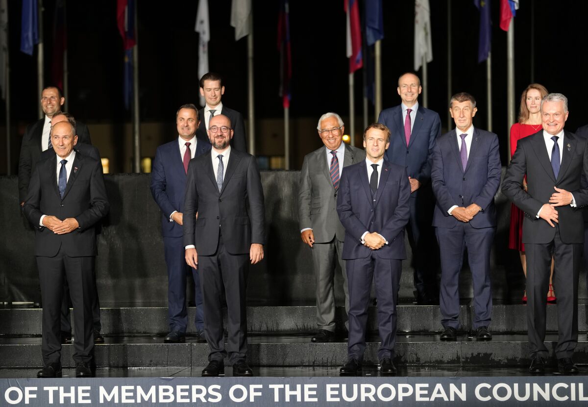 Front row left, to right, Slovenia's Prime Minister Janez Jansa, European Council President Charles Michel, French President Emmanuel Macron and Lithuania's President Gitanas Nauseda pose with other EU leaders during a group photo at an EU summit, at the Brdo Castle in Kranj, Slovenia, Tuesday, Oct. 5, 2021. EU leaders are meeting Tuesday evening to discuss increasingly tense relations with China and the security implications of the chaotic U.S.-led exit from Afghanistan, before taking part in a summit with Balkans leaders on Wednesday. (AP Photo/Darko Bandic)