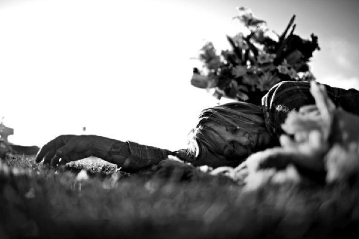 LANCASTER, CA - DECEMBER 27, 2011 -- Leslie Greenberg lies in the grass at a park after leaving flowers at the nearby grave of her boyfriend Andrew Corless, who died in 2006 of prescription drug and alcohol intoxication. ( Liz O. Baylen / Los Angeles Times)