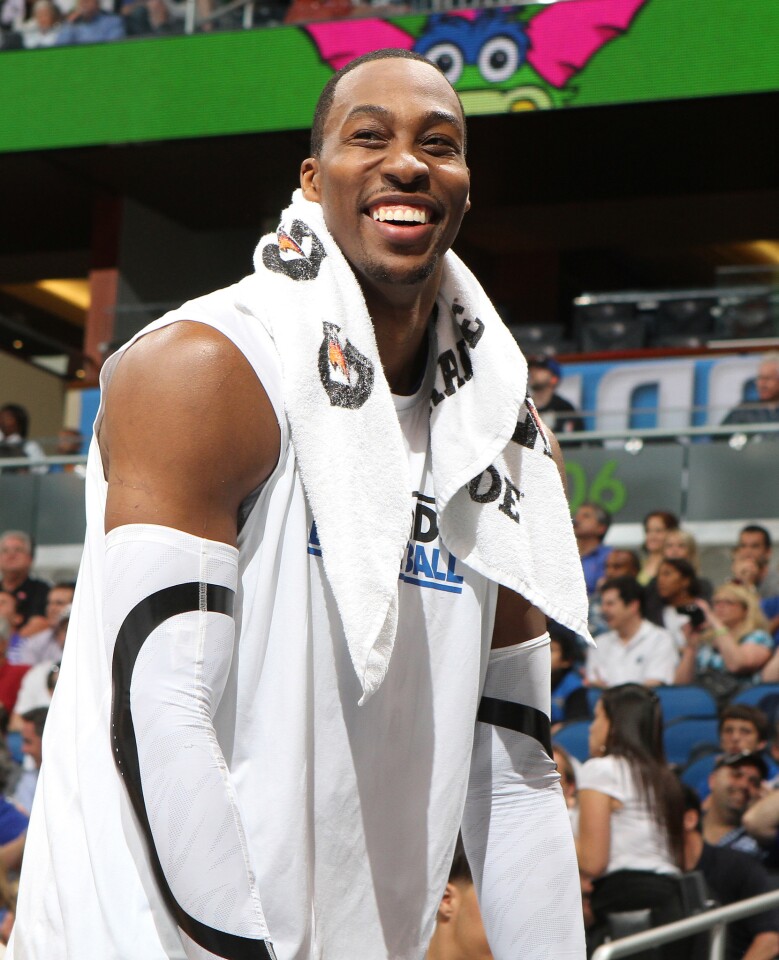 Orlando center Dwight Howard smiles from the bench during the Magic's game against the Miami Heat in Orlando, Fla. Tuesday, March 13, 2012.