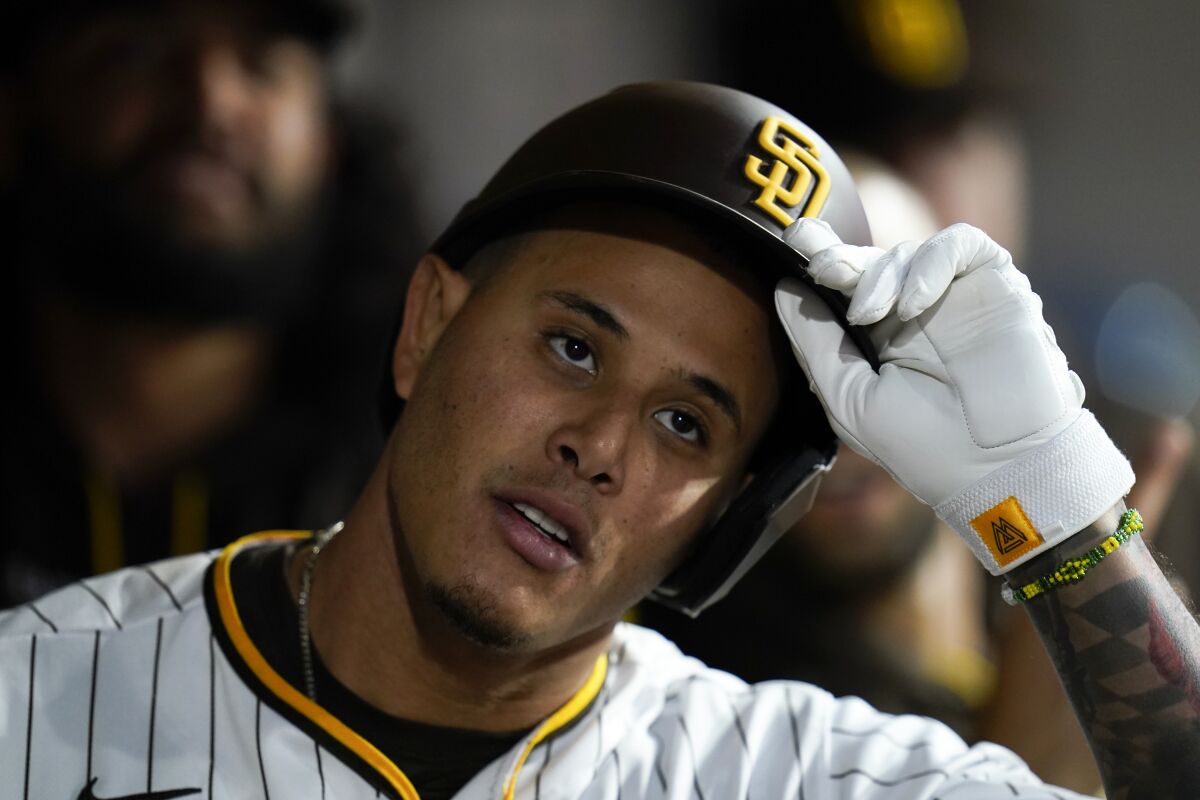 San Diego Padres' Manny Machado takes off his helmet in the dugout after hitting a home run during the fourth inning of a baseball game against the Miami Marlins, Thursday, May 5, 2022, in San Diego. (AP Photo/Gregory Bull)
