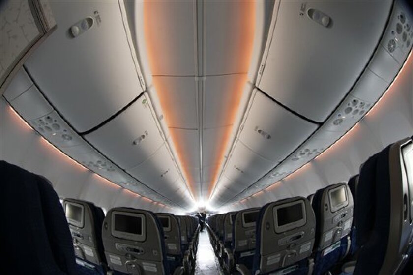 The orange sunrise sunset LED atmospheric lighting of the interior of a Boeing 737-900ER is seen on display at the Farnborough International Airshow, Farnborough, England, Tuesday, July 10, 2012. Boeing Co. and arch-rival Airbus were caught in a fierce dogfight for orders at the Farnborough Airshow Tuesday, with both aircraft manufacturers unveiling multi-billion deals — crucial at a time of global economic unease. Boeing was the big winner for the second day as it clinched a further two big orders worth a little more than $11 billion for its remodeled short-haul 737 aircraft. Meanwhile, European rival Airbus unveiled its first billion-dollar order at this year's airshow. (AP Photo/Sang Tan)