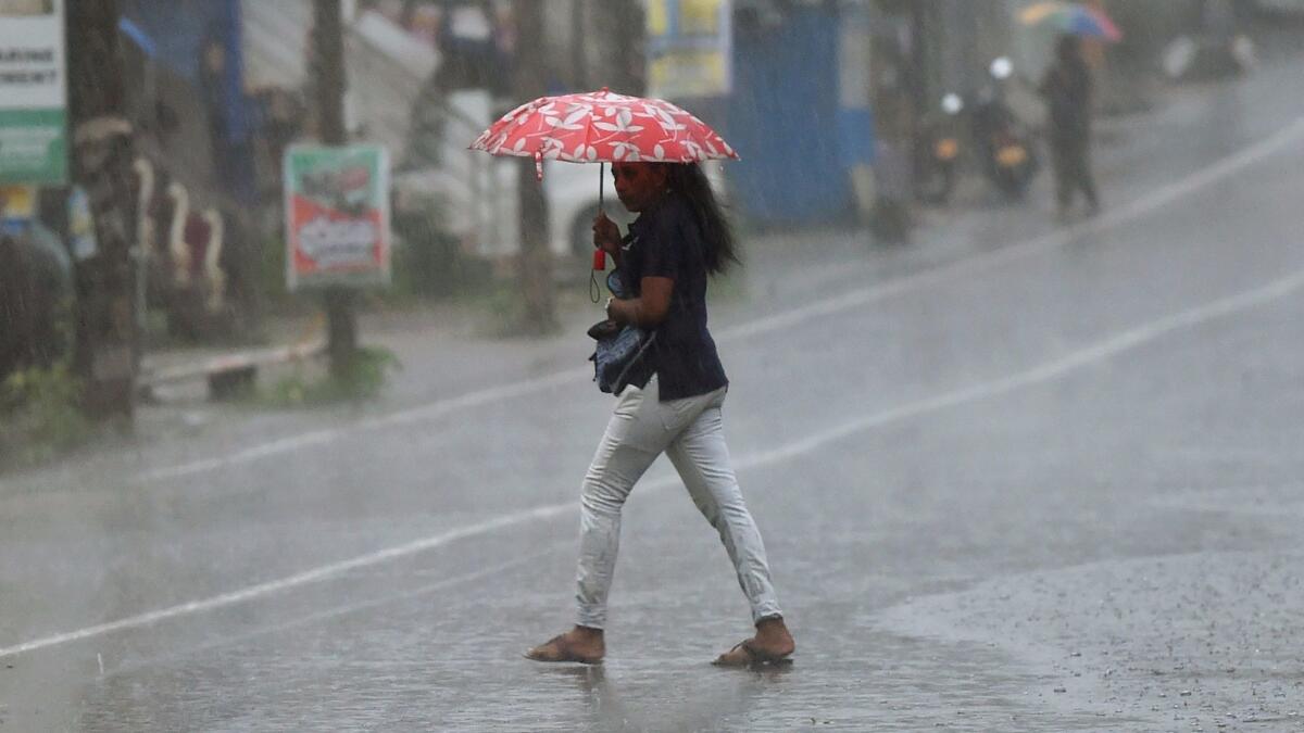 A woman walks through a downpour in Colombo, Sri Lanka on May 26.