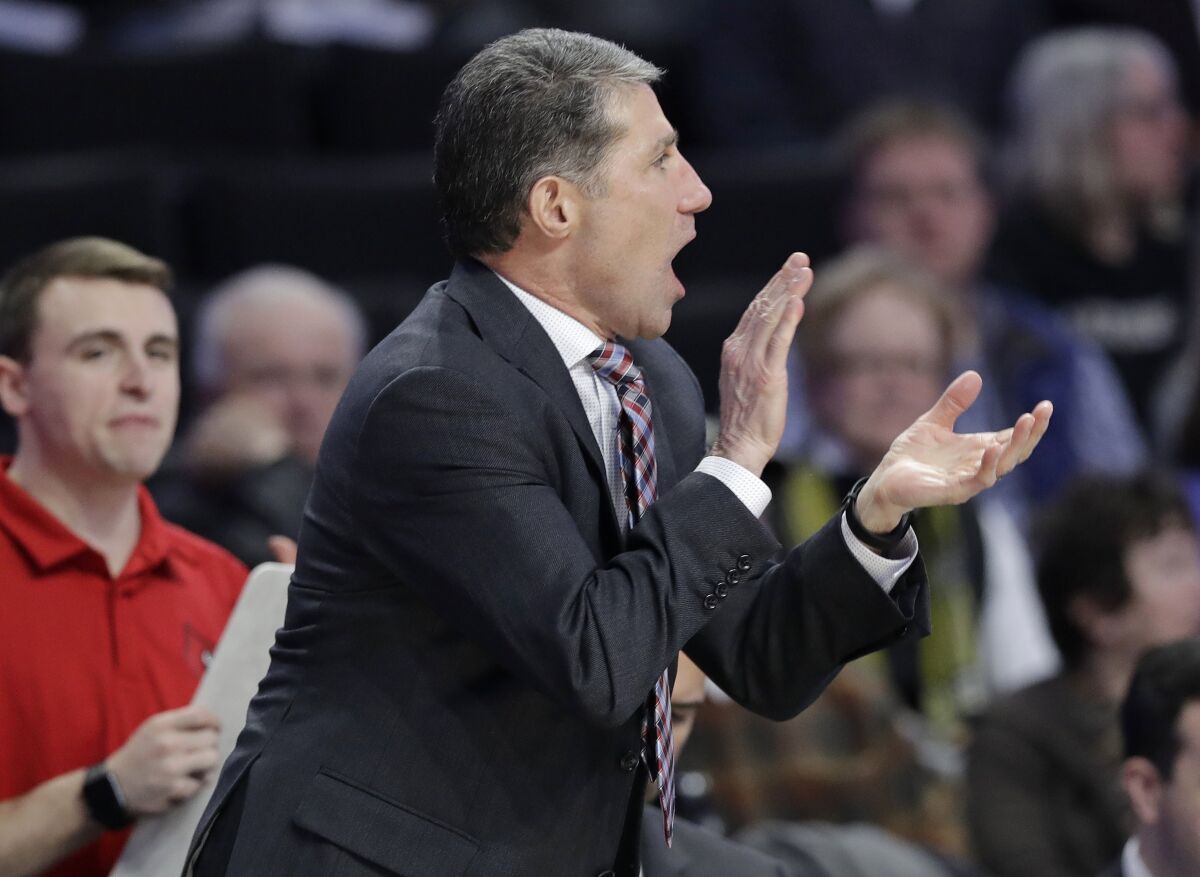 FILE - In this Jan. 30, 2019, file photo, Louisville assistant coach Dino Gaudio cheers on the team against Wake Forest during the second half of an NCAA college basketball game in Winston-Salem, N.C. Federal authorities have charged Gaudio with attempting to extort the university after his dismissal from the team. Gaudio threatened to go to the media with alleged NCAA violations by the team, according to a charging document filed in federal court. (AP Photo/Chuck Burton, File)