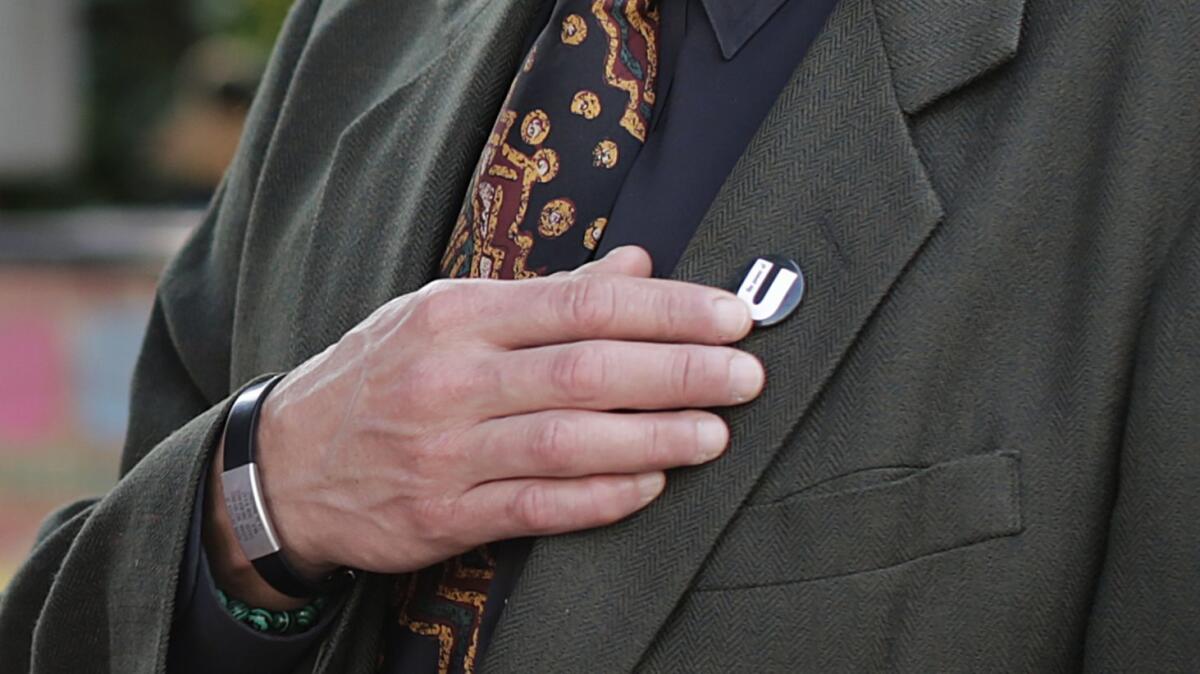 Adan Ortega of Fullerton puts his hand on a U pin after participating in Miguel Luna's project.