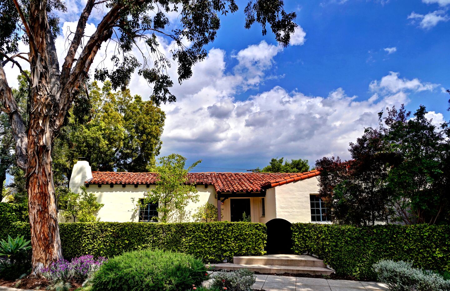 The Spanish Colonial Revival-style home, designed by George S. Hamrick, was built in 1925 buy local contractor Fritz Ruppel for his mother, Gertrude. The one-story residence, which has a clay tile roof and reinforced-concrete walls, was built at a cost of $7,000. Listed for $1.495 million, the charming residence opens to a grand living with cathedral-style ceilings, exposed beams and a wood-burning fireplace. The formal dining room sits off the kitchen, which has been updated with a stainless steel range and farmhouse-style sink. A French door in the kitchen leads outside to a small herb garden. The 1,825-square-foot floor plan has three bedrooms and two bathrooms. Tilework in one of the two bathrooms is reminiscent of the work of master craftsman Earnest Batchelder.