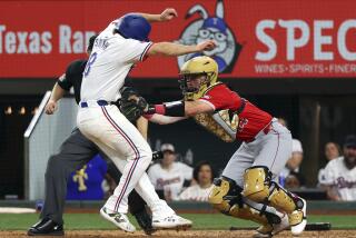 Texas Rangers' Josh Smith is tagged out at the plate by Angels catcher Logan O'Hoppe in the 10th inning