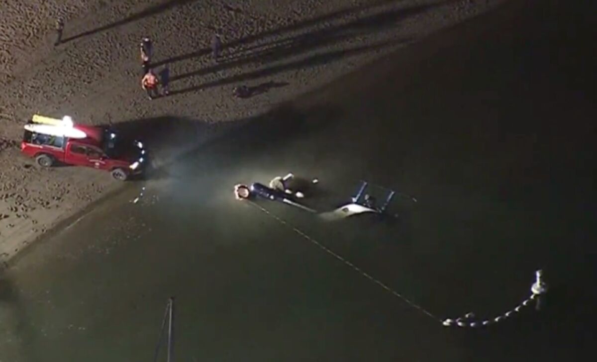 A helicopter sits in the water after it crashed. 