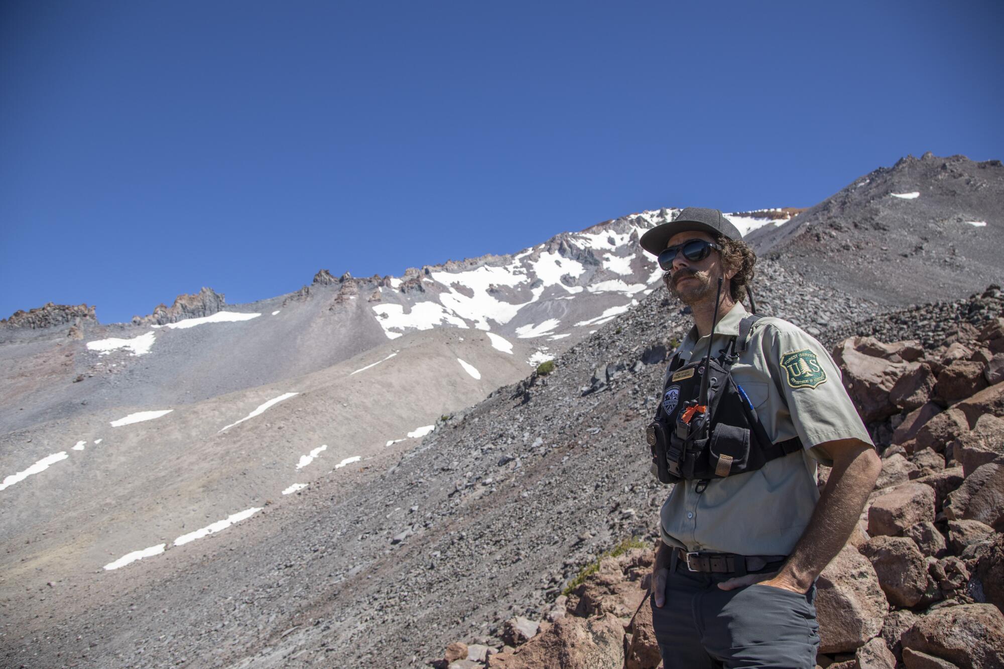 A forest ranger in uniform on a rocky slope