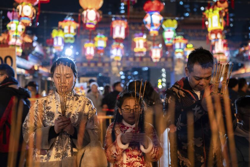 Fieles rezan mientras encienden varas de incienso en un templo para recibir el Año Nuevo Lunar, en Hong Kong, el 9 de febrero de 2024. (AP Foto/Louise Delmotte)