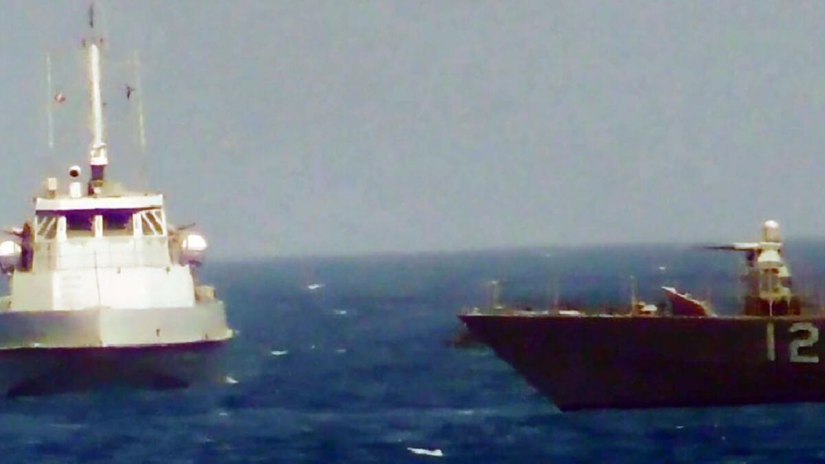 An image from video shows an Iranian boat, left, heading toward the U.S. Navy patrol ship Thunderbolt on Tuesday in the Persian Gulf. The U.S. vessel fired warning shots at the Iranian boat before the encounter was over.