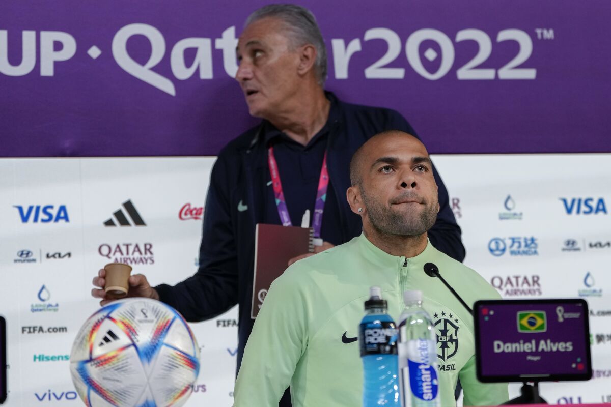 El brasileño Dani Alves (delante) y el seleccionador Tite durante una conferencia de prensa en la víspera del partido