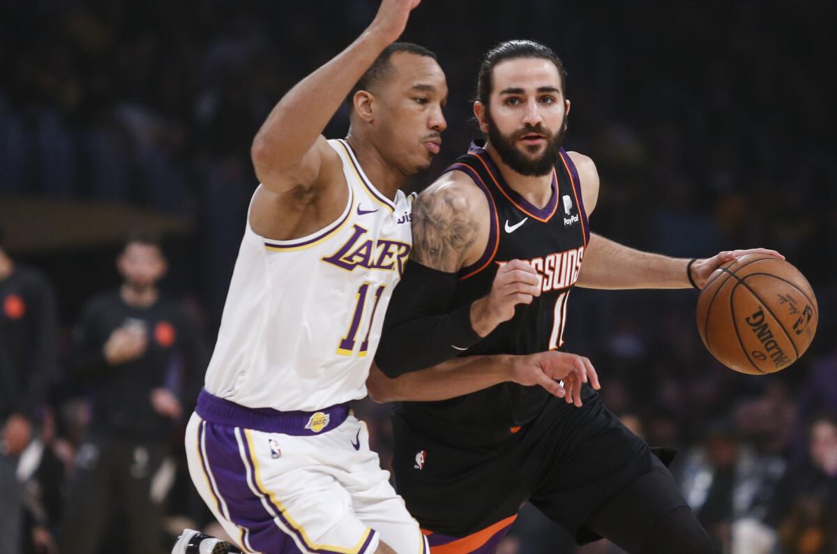 Lakers guard Avery Bradley, left, tries to cut off a drive by Phoenix Suns guard Ricky Rubio.