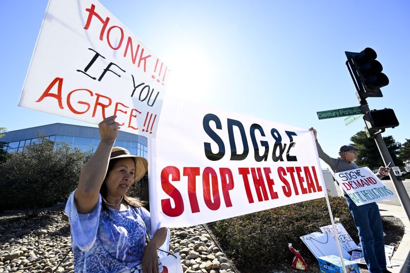 Amy Le, left, and Richard Niwinski protest rate hikes in front of SDG&E headquarters Feb. 6, 2023 in San Diego. (Photo by Denis Poroy)