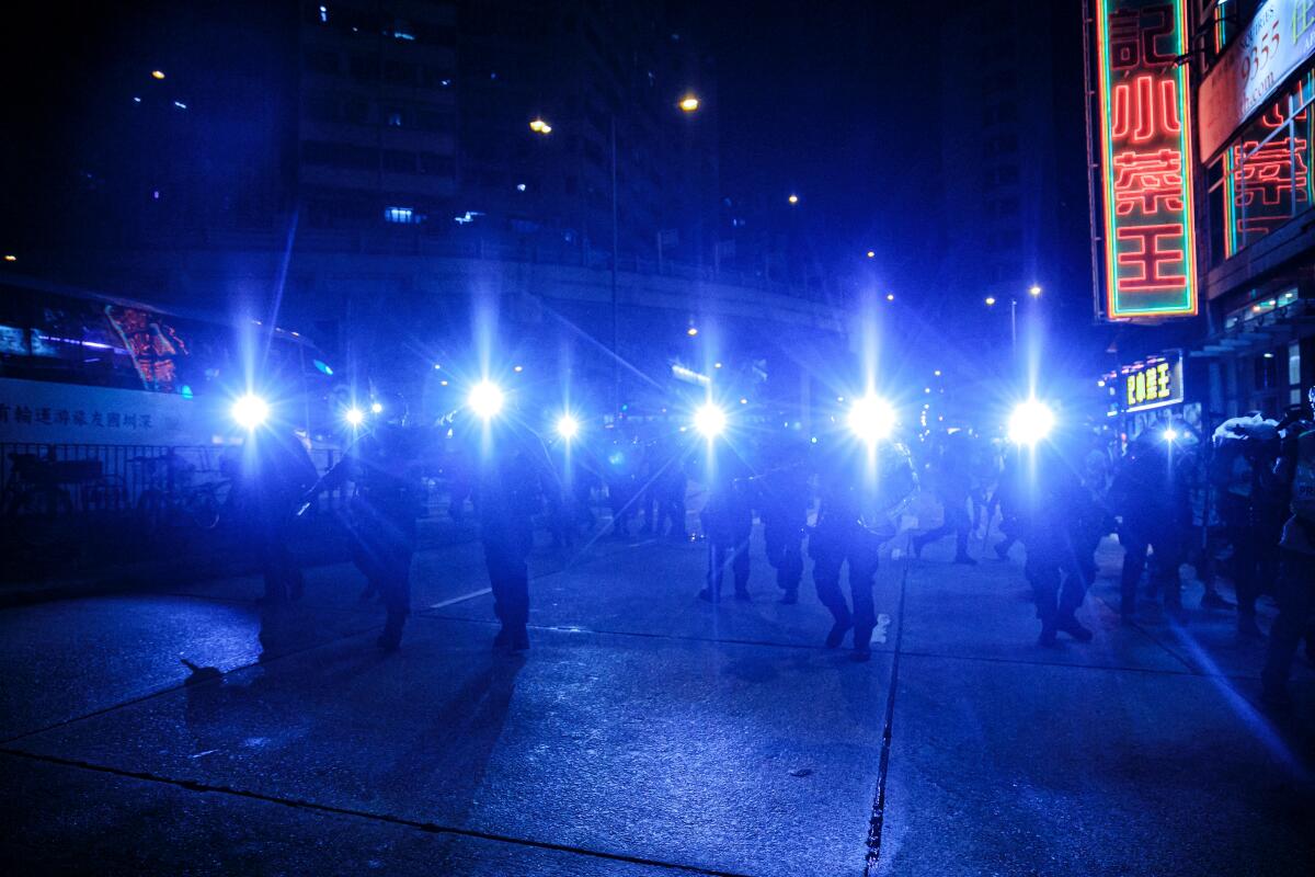 Hong Kong elite police officers chase protesters after they tried to cause a disturbance near the Mongkok Police Station in Hong Kong in 2019.