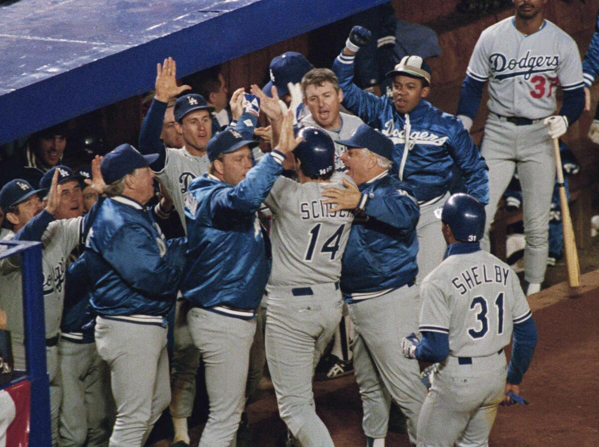 Dodgers' Mike Scioscia is greeted by teammates and manager Tommy Lasorda after hitting a game-tying, two–run homer.