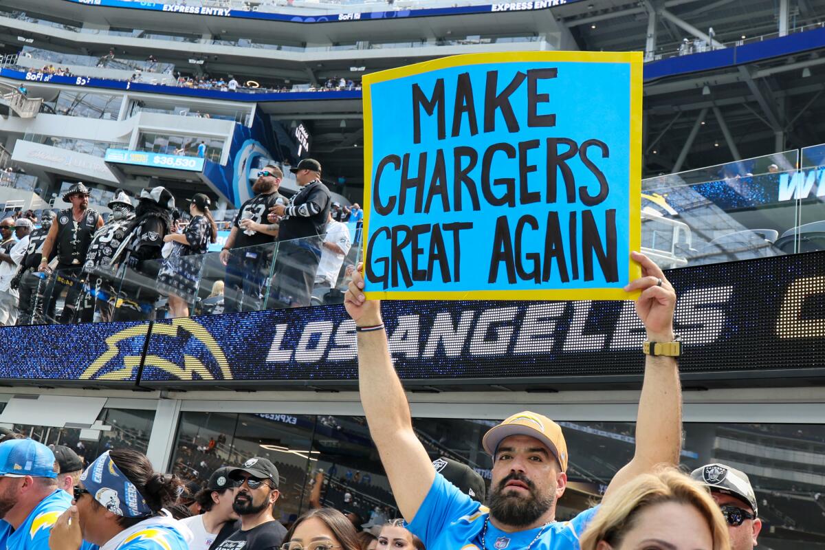 A Chargers fan holds up a sign that reads: "Make chargers great again."