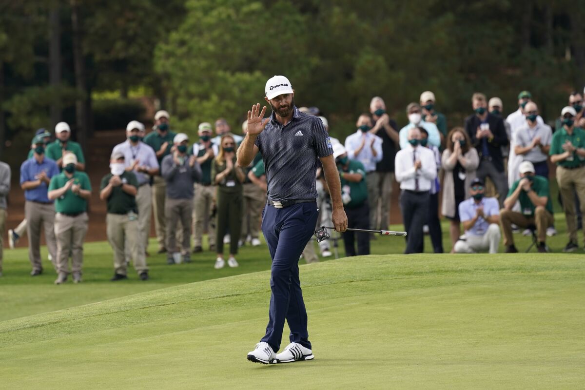 FILE - Dustin Johnson waves after winning the Masters golf tournament in Augusta, Ga., in a Sunday, Nov. 15, 2020, file photo. Some volume is returning to the Masters, just maybe not the head-turning roars. Augusta National Chairman Fred Ridley said Tuesday, Jan. 12, 2021, the club intends to allow a limited number of spectators for the Masters on April 8-11, provided it can be done safely, given the coronavirus pandemic. (AP Photo/David J. Phillip, File)