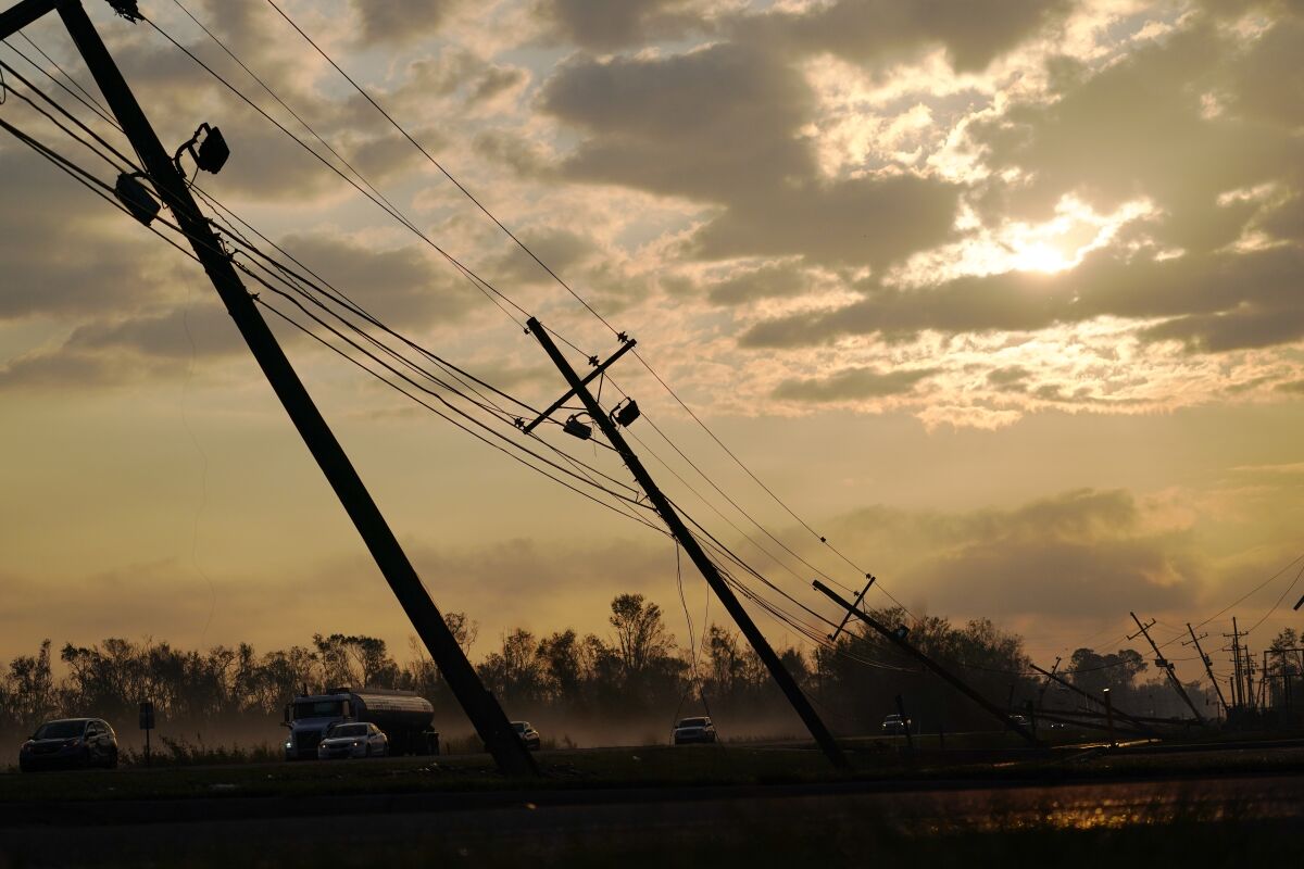 Utility poles lean over a road in the aftermath of Hurricane Ida in Reserve, La.