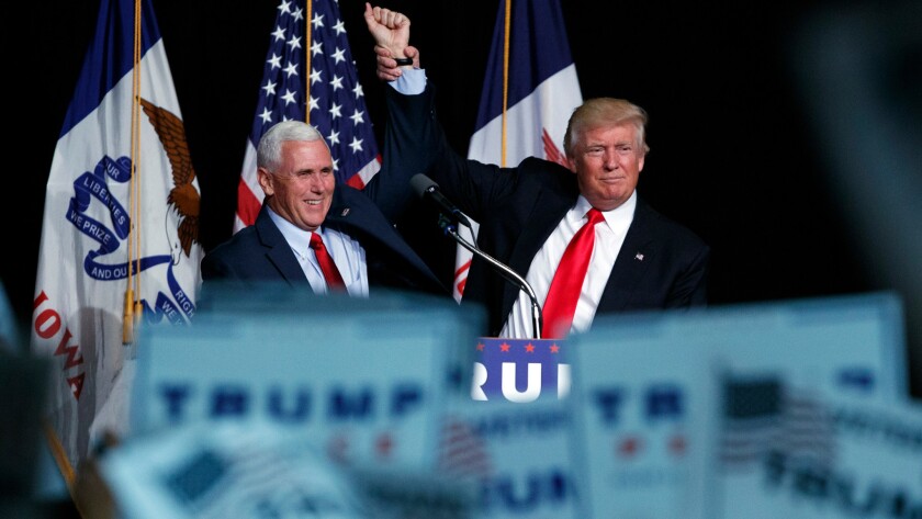 Republican presidential candidate Donald Trump, right, and vice presidential candidate Gov. Mike Pence, R-Ind., join hands during a campaign rally on Friday in Des Moines.