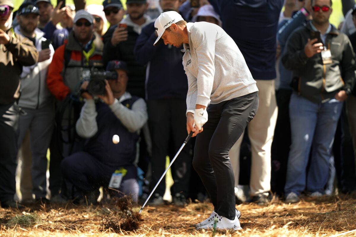 Sam Burns hits from the pine straw on the 18th fairway during the second round of play in The Players Championship golf tournament Sunday, March 13, 2022, in Ponte Vedra Beach, Fla. (AP Photo/Gerald Herbert)