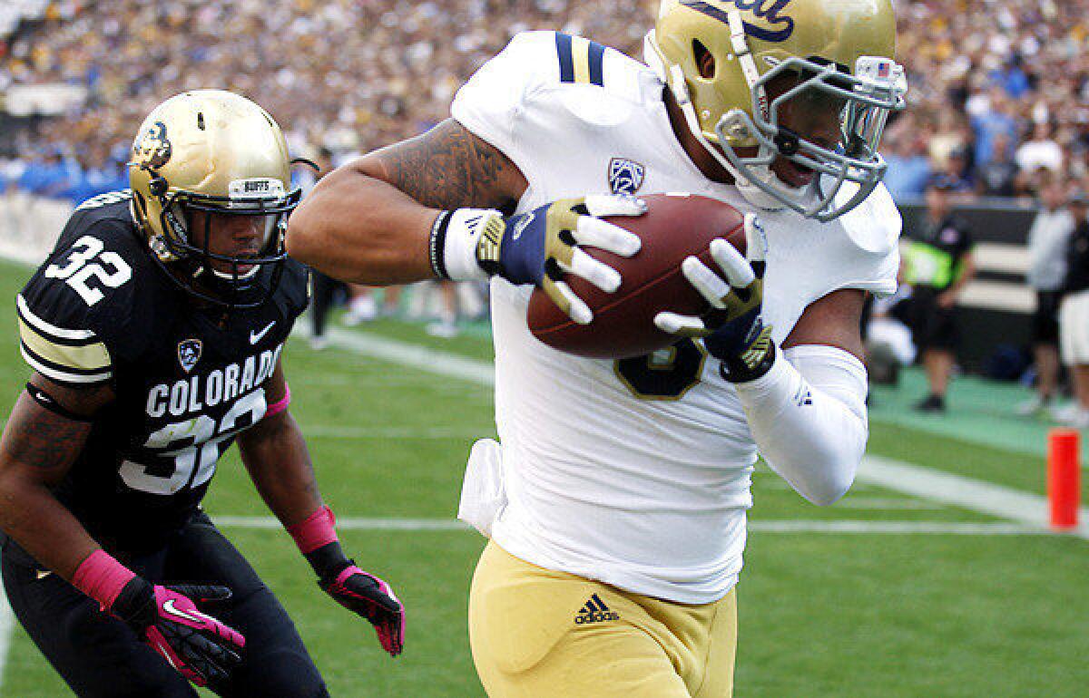 UCLA receiver Darius Bell snags a 17-yard touchdown pass in front of Colorado linebacker Paul Vigo in the second quarter Saturday.