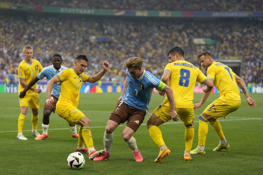El belga Kevin De Bruyne pelea por mantener el control del balón entre los ucranianos Ruslan Malinovskyi y Andriy Yarmolenko en el encuentro del Grupo E de la Eurocopa el miércoles 26 de junio del 2024. (AP Foto/Matthias Schrader)