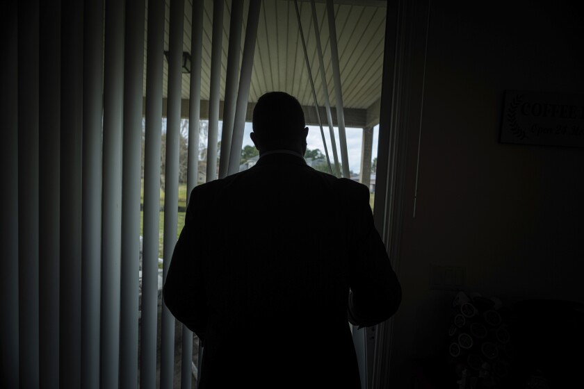 Joseph Moore looks out of a window at his home in Jacksonville, Fla., on Tuesday, Dec. 7, 2021. Moore worked for nearly 10 years as an undercover informant for the FBI, infiltrating the Ku Klux Klan in Florida, foiling at least two murder plots, according to investigators, and investigating ties between law enforcement and the white supremacist organization. “From where I sat, with the intelligence laid out, I can tell you that none of these agencies have any control over any of it. It is more prevalent and consequential than any of them are willing to admit.” (AP Photo/Robert Bumsted)
