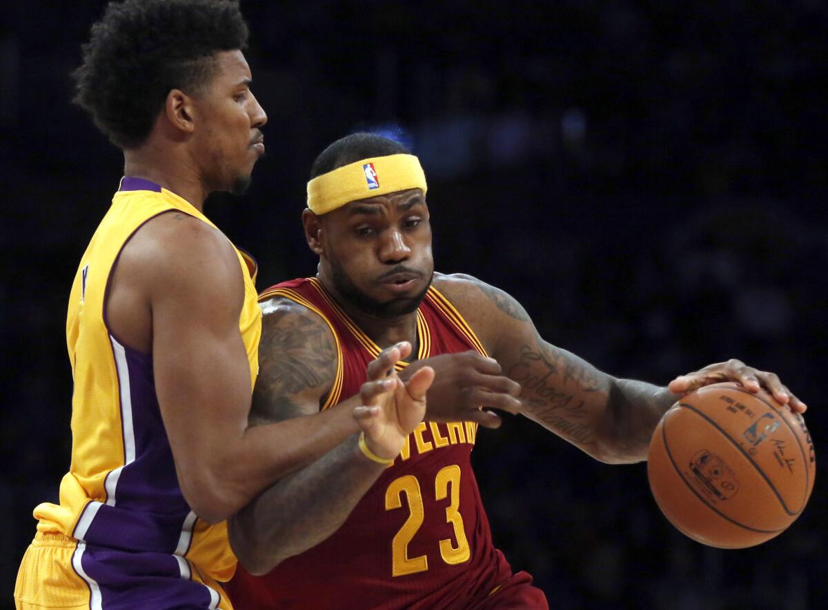 Lakers forward Nick Young tries to cut off a drive by Cavaliers forward LeBron James during their game last month at Staples Center.