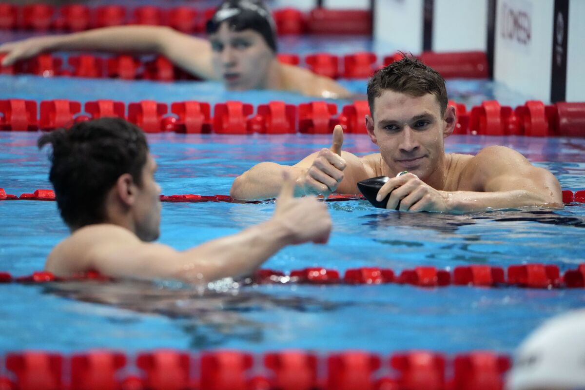 Ryan Murphy gives a thumbs up to Evgeny Rylov in the pool at the Tokyo Olympics.