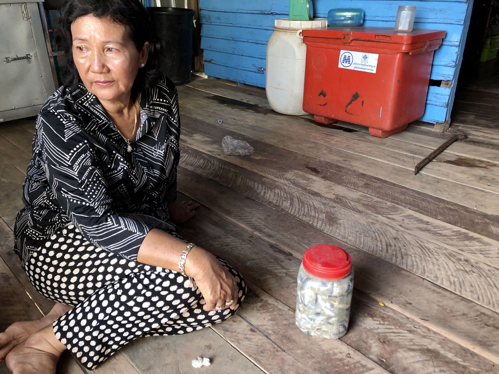 Activist Phat Phalla in her kitchen in Chhnok Tru, Cambodia, with a jar of prahok, a fermented fish paste, an essential ingredient in Cambodians' diets.