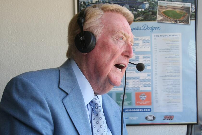 Vin Scully prepares to call a game at Dodger Stadium on July 3, 2012. Scully's broadcast career with the Dodgers began in 1950.