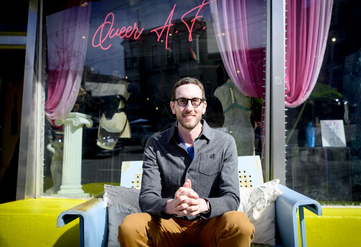 Senator Scott Wiener sits for a photo in front of a shop formerly owned by Harvey Milk in San Francisco