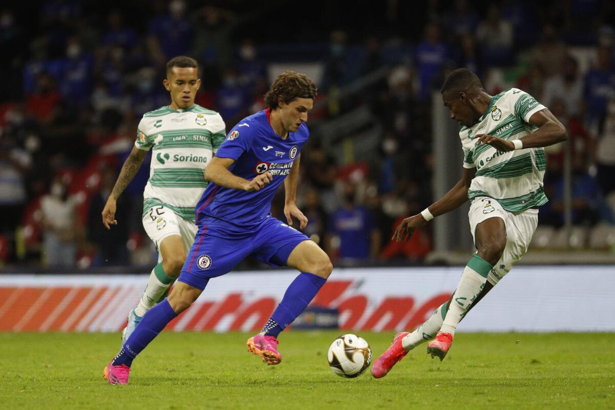 Cruz Azul's Santiago Gimenez, center, dribbles the ball in front of Laguna Santos' Felix Torres 