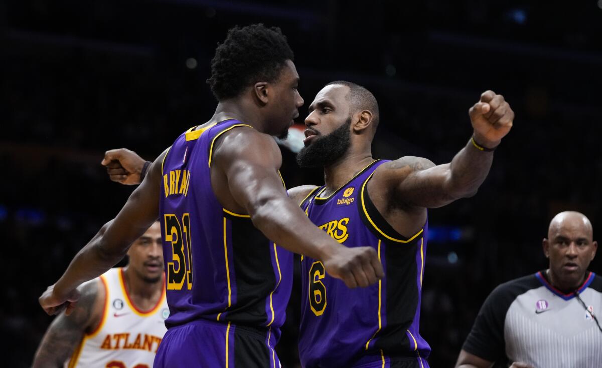 Lakers center Thomas Bryant, left, celebrates with LeBron James after scoring and drawing a foul.