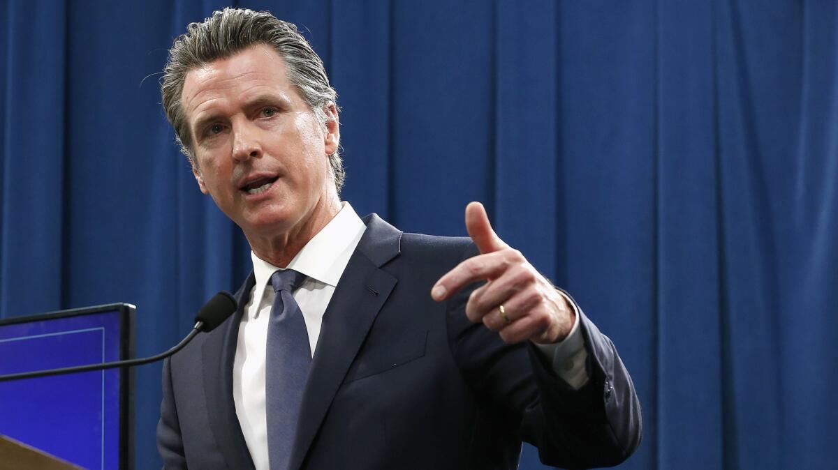 Gov. Gavin Newsom gestures as he speaks at a lectern