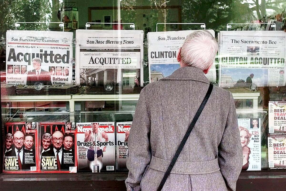 A woman views newspaper headlines at a newsstand in Sacramento in 1999.