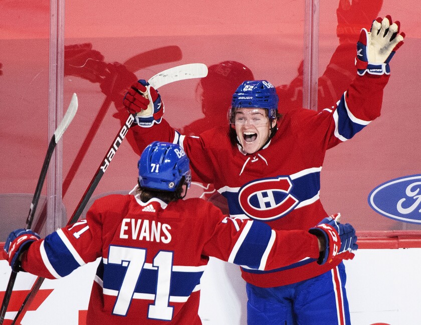 FILE - In this May 1, 2021, file photo, Montreal Canadiens' Cole Caufield (22) celebrates with teammate Jake Evans after scoring against the Ottawa Senators during overtime of an NHL hockey game in Montreal. Caufield was dominating college hockey in late March and by late May was a regular in the lineup of the most storied franchise in the NHL, helping the Canadiens advance to the third round of the playoffs. (Graham Hughes/The Canadian Press via AP, File)