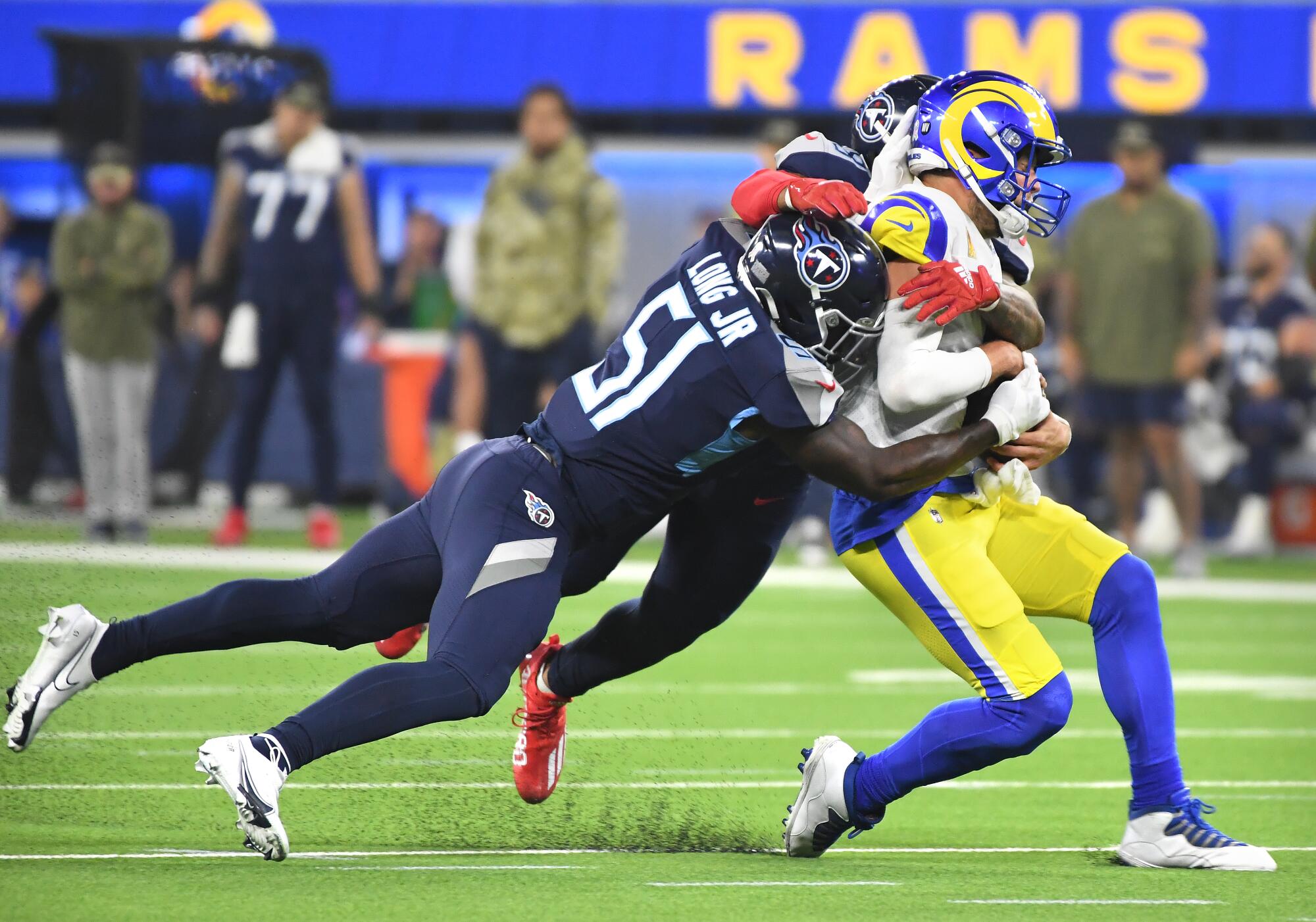 Rams quarterback Matthew Stafford is brought down by Titans linebackers David Long Jr. and Harold Landry
