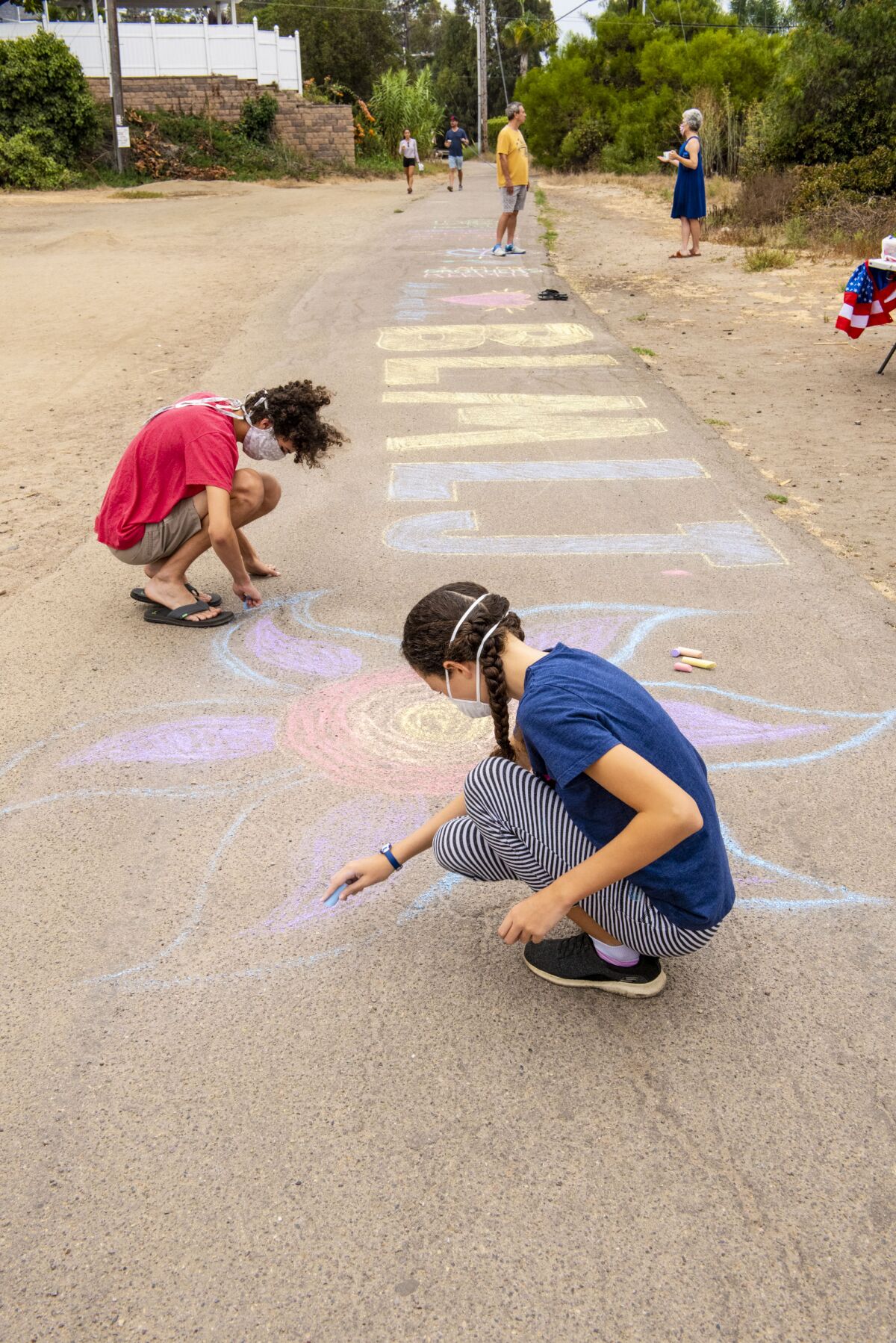 People contribute chalk art during a community Labor Day event to support the Black Lives Matter movement.