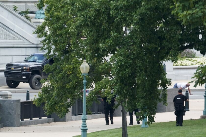 FILE - A man is apprehended after being in a pickup truck parked on the sidewalk in front of the Library of Congress' Thomas Jefferson Building, as seen from a window of the U.S. Capitol, Aug. 19, 2021, in Washington. A man who caused evacuations and an hourslong standoff with police on Capitol Hill when he claimed he had a bomb in his pickup truck outside the Library of Congress pleaded guilty on Friday, Jan. 27, 2023, to a charge of threatening to use an explosive. Floyd Ray Roseberry faces up to 10 years behind bars and is scheduled to be sentenced in June. (AP Photo/Alex Brandon, File)