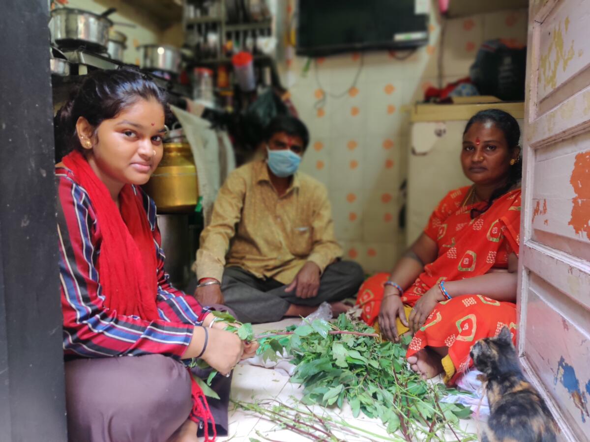 Vishakha, left, Ashok and Renuka Kunchikurve are pictured in their one-room house in Dharavi, a slum in Mumbai, India.