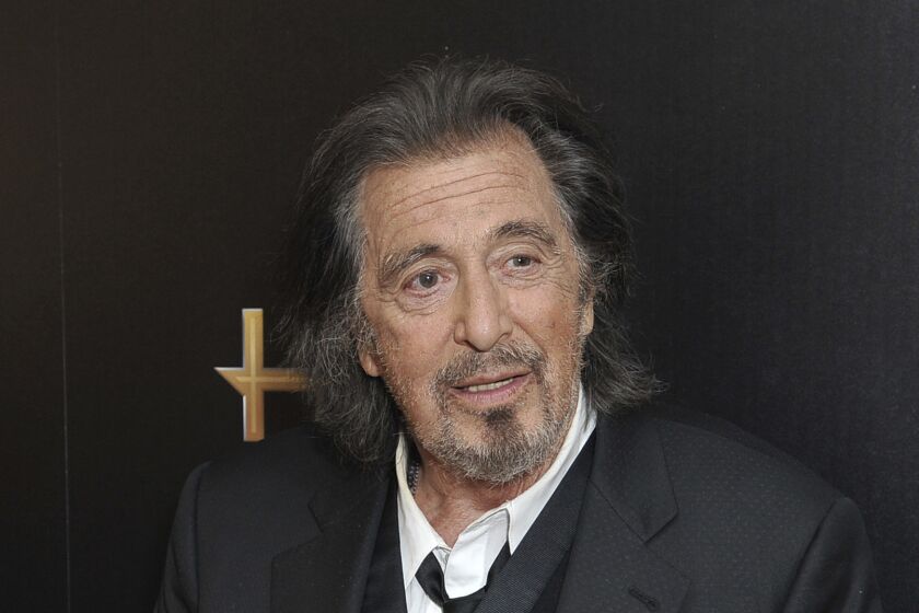 Al Pacino poses in a black suit and tie.