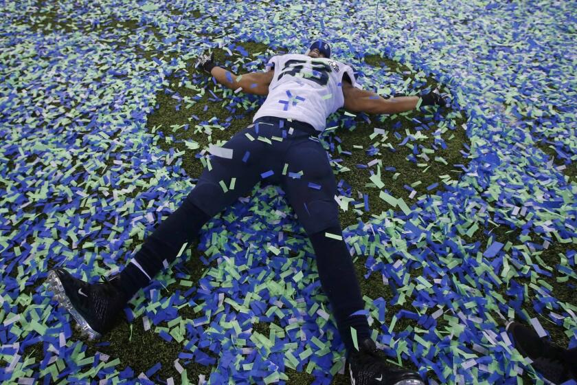 Super Bowl MVP Malcom Smith makes an angel in the confetti after his team defeated the Bronocs.