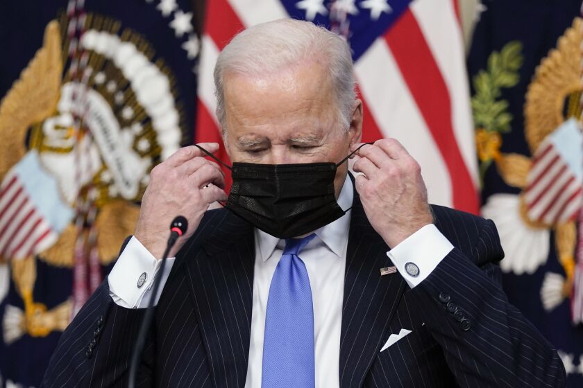 President Joe Biden adjusts his face covering as he speaks during a meeting with business leaders about the holiday shopping season, in the library of the Eisenhower Executive Office Building on the White House campus, Monday, Nov. 29, 2021, in Washington. (AP Photo/Evan Vucci)