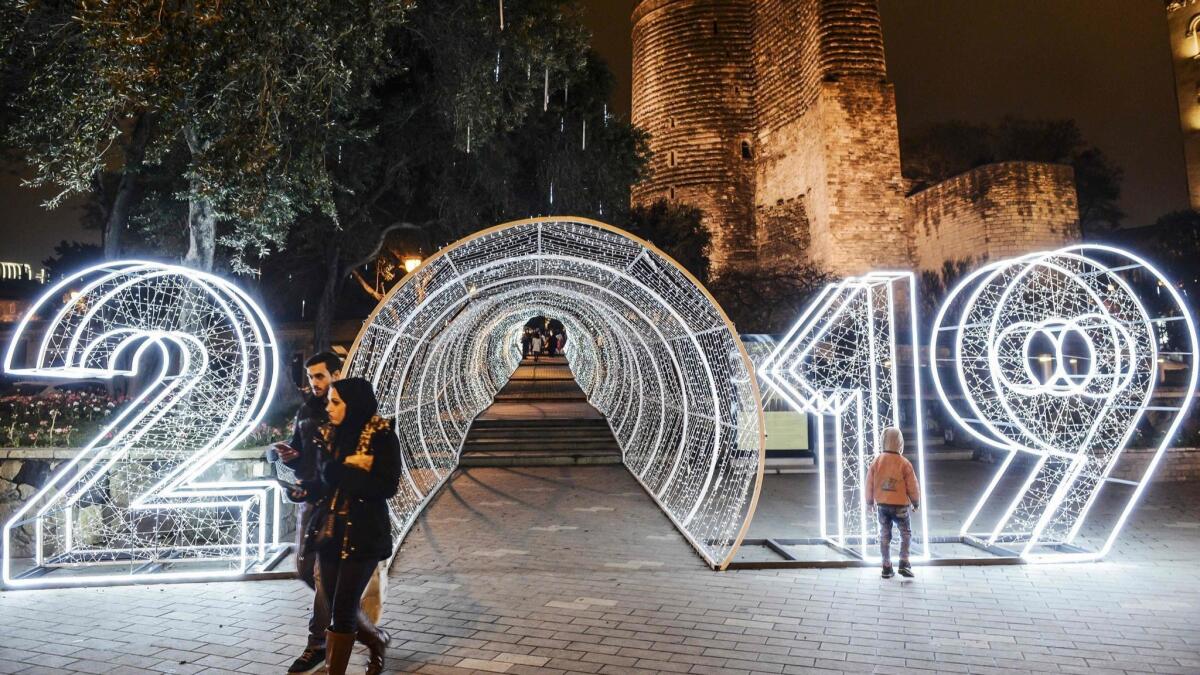 People walk past New Year decorations in front of the Maiden Tower this month in the old city of central Baku, Azerbaijan.