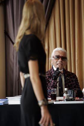 Designer Karl Lagerfeld looks over a model at the Beverly Hills Hotel in preparation for an upcoming show.