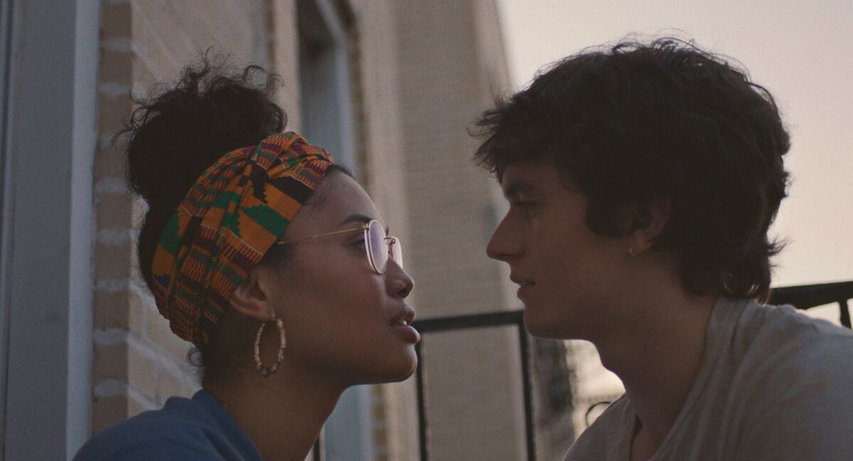A young woman and a young man look into each other's eyes.